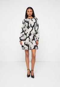 Īsām piedurknēm kleita ar melnbaltu lapu rakstu, izgatavota no viegla auduma ar plati izgrieztu dizainu un apaļu kakla izgriezumu.