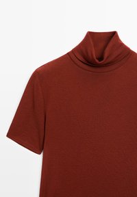 Kurzärmliges, burgunderrotes Rollkragenoberteil mit weicher, glatter Textur und figurbetontem Design, das einen umgeschlagenen Kragen und klare Linien aufweist.