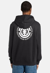 Black hoodie made of soft fabric, featuring a large white circular logo on the back with text "WATER. FIRE. EARTH. WIND." at the edges.