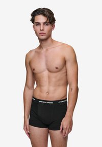Fekete boxeralsó, testhezálló fazonban, puha anyagból készült, fehér "PEGADOR" logóval a derékrészen.