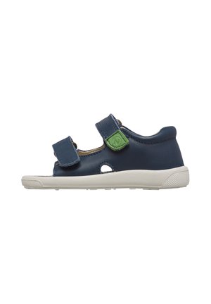 Sandalo blu navy per bambini con due cinturini regolabili, patch con logo verde, punta e tallone aperti, e suola bianca flessibile.