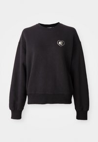 Felpa nera in misto cotone, con scollo rotondo, maniche lunghe e un'applicazione ricamata a forma di cuore sul petto.