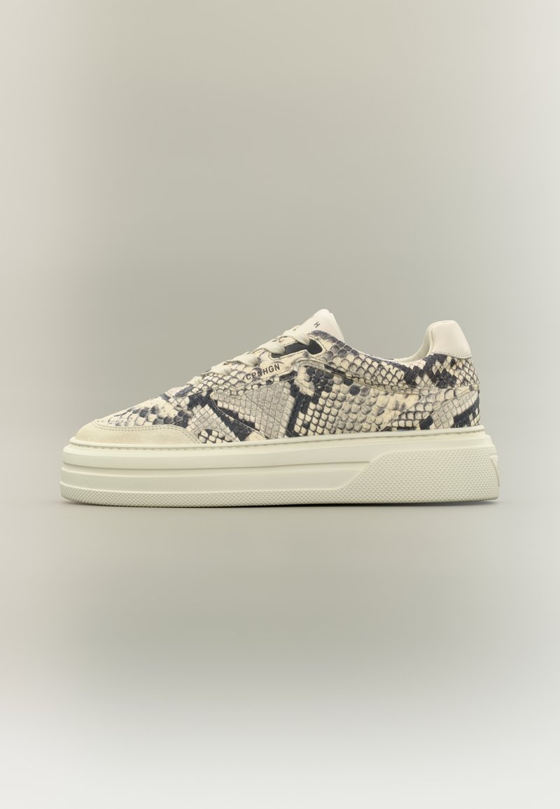 Baskets basses avec semelle blanche et motif peau de serpent beige et noir sur la tige, vues de côté sur un fond clair.