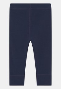 Leggings navy en tissu extensible, dotés d'un design sans couture avec un ourlet à la cheville et de subtiles coutures décoratives.