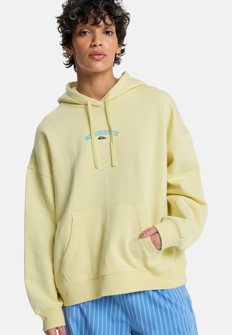 Sweat à capuche jaune en tissu doux, doté d'une poche avant, d'un cordon de serrage et d'un détail de logo bleu. Coupe ample avec poignets côtelés.