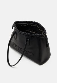 Musta nahkainen kassi, jossa on muotoiltu yläosa, kaksinkertaiset kahvat, kohokuvioitu logo ja vetoketjullinen sisätasku turvallista säilytystä varten.