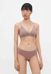Ljus mauve bralette med justerbara remmar och ett brett band. Matchas med högmidjade trosor. Slät textur och minimala sömmar.