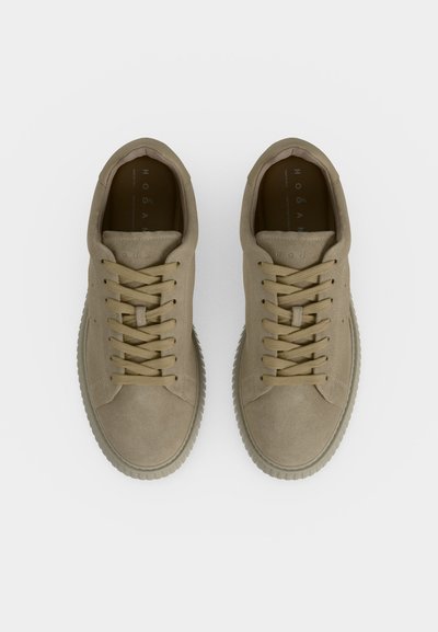 Paire de baskets en daim beige à lacets vue de dessus sur fond blanc.
