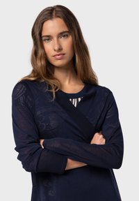 Marinblå omslagstopp i lätt tyg, med långa ärmar, blommönster och en kontrasterande randig panel vid halsringningen.