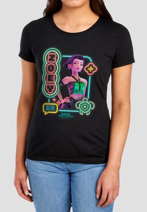 Woman wearing black fitted t-shirt with colorful K-pop Demon Hunters character "Zoey" and neon-style graphic designs.