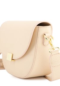 Beige Leder Umhängetasche mit runder Form, goldener Hardware, einem Klappverschluss und strukturierter Oberfläche. Verstellbarer Tragegurt inklusive.