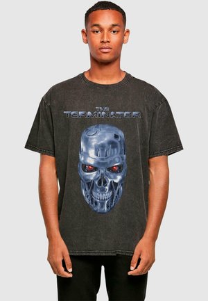 Black oversized T-shirt made of cotton, featuring a large blue and red graphic of a robotic skull with text "THE TERMINATOR" above.