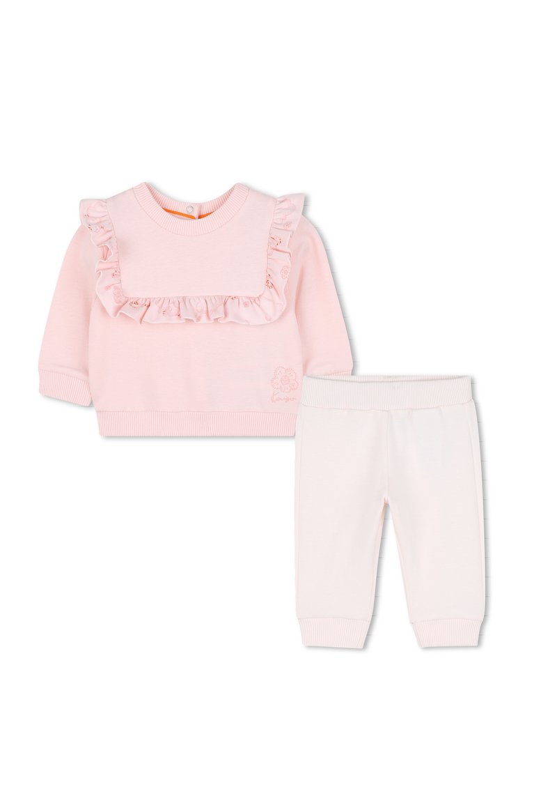 Sweatshirt en coton rose avec col à volants et broderies florales, accompagné d'un pantalon en coton blanc avec taille élastique et poignets.