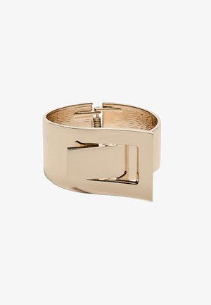 Zapestnica iz zlatega kovinskega materiala z gladko površino in izrezanim pravokotnim dizajnom. Ima teksturirano notranjost in pomično zapiranje.