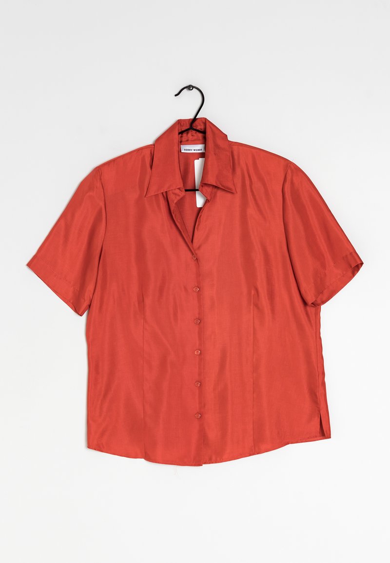 Kortärmad skjorta utan krage i rostorange satinmaterial, med knappstängning fram och sidoflikar för luftcirkulation vid fållen.
