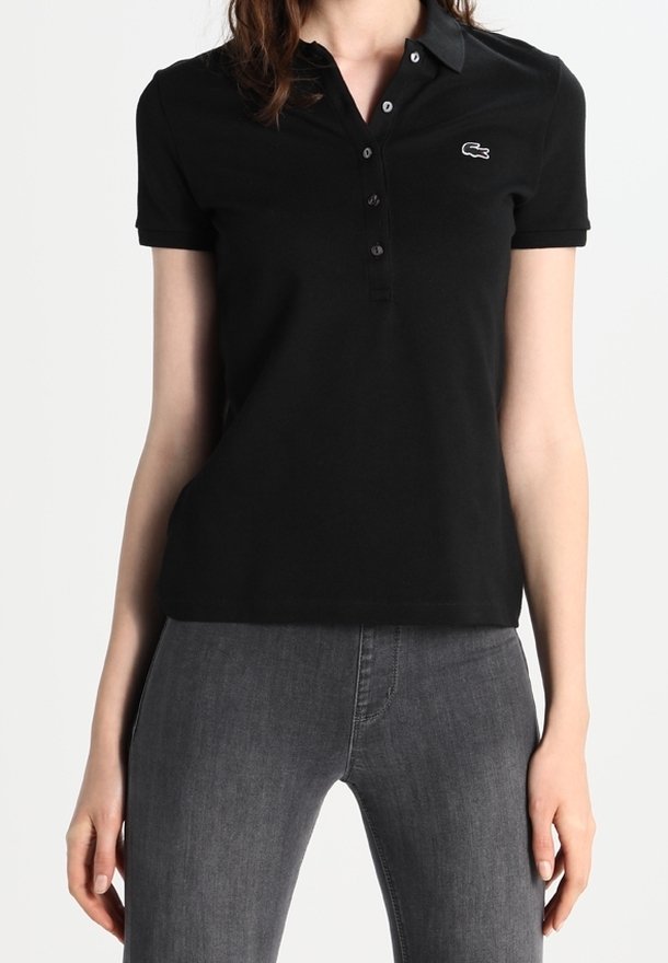 Polo noir avec col, manches courtes et une patte de boutonnage à cinq boutons. Présente le logo Lacoste sur le côté gauche de la poitrine. Matière en coton.