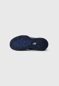 Sole of a blue athletic shoe with textured geometric tread pattern and white New Balance logo in the center.