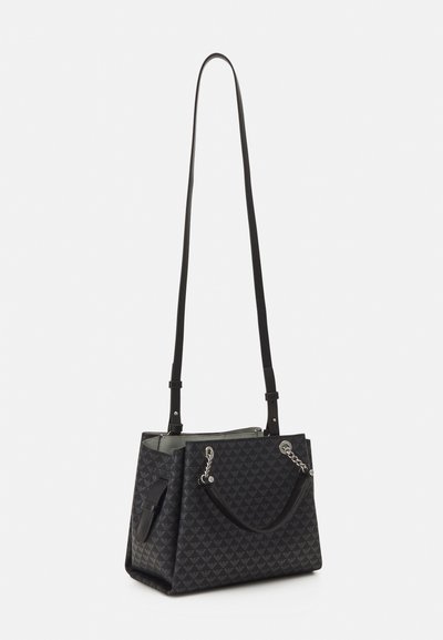 Borsa a tote nera con design geometrico trapuntato, dettagli con catena, doppi manici superiori e rivestimento interno liscio. Presenta una tracolla regolabile.