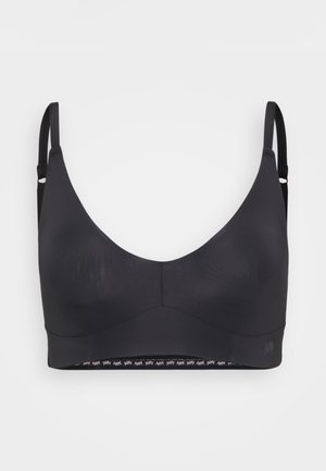 Svart trådløs BH med glatt stoff, brede stropper og sømløst design. Har en merket elastisk kant langs bunnen.