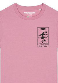 Helles rosa Baumwoll-T-Shirt mit rundem Ausschnitt. Auf der Vorderseite befindet sich eine schwarze grafische Illustration einer Figur, beschriftet mit "DER NARR", vor einer Stadtsilhouette.