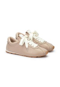 Baskets en cuir beige avec des lacets crème, bout rond, détails discrets en studs sur les côtés et semelle en caoutchouc flexible.