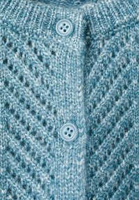 Cardigan en tricot bleu clair avec un motif chevron texturé et deux boutons ronds. Matière douce avec fibres visibles et détails de couture.
