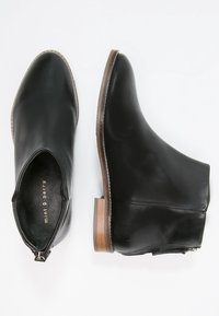 Czarne skórzane botki za kostkę z zaokrąglonym noskiem, zasuwane na zamek z boku i z drewnianym obcasem. Gładka tekstura z minimalnymi detalami szycia.
