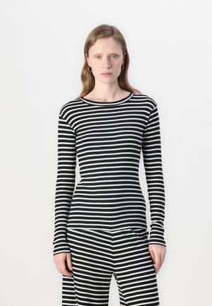 Haut à rayures noires et blanches à manches longues avec un col rond, fabriqué en tissu côtelé, associé à un pantalon rayé assorti.