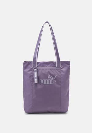 Violetti Puma-kangaskassi, jossa on kaksinkertaiset kahvat ja etutasku, jossa on vetoketju sekä Puma-logo ja teksti.