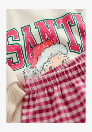 Kerman huppari, jossa on vihreä ja vaaleanpunainen "SANTA" -teksti ja sarjakuvamainen joulupukkikasvo, yhdistettynä vaaleanpunaisiin ja valkoisiin ruudullisiin pyjamahousuihin, joissa on joustava vyötärö.