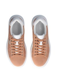 Sneaker beige con pannelli testurizzati e accenti bianchi, dotate di lacci piatti, punta arrotondata e soletta imbottita su una suola in gomma bianca.