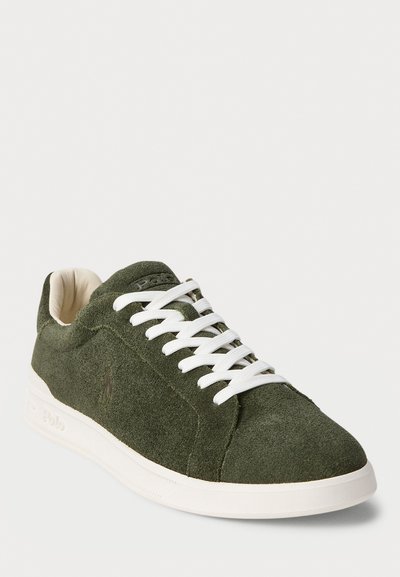Adidași din suede de culoare verde închis, cu șireturi și talpică albă, design la nivelul gleznei, și căptușeală interioară moale de culoare crem.