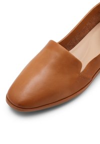 Brown leather slip-on shoe with a pointed toe, smooth texture, minimal stitching, and a soft interior lining.