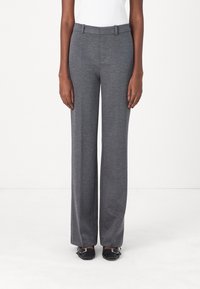 Šedé kalhoty s širokými nohavicemi vyrobené z měkké látky, s hladkou texturou, poutky na opasek a přizpůsobeným střihem, spárované s černými botami.
