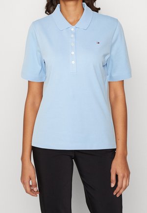 Polo bleu clair à manches courtes, avec un col et une patte de boutonnage à trois boutons. Doté d'un petit logo sur la poitrine gauche. Matière en coton douce.