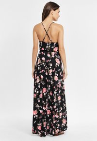 Rochie maxi cu imprimeu floral negru, prezentând bretele subțiri în cruce, un corset ajustat, fustă fluidă și un material ușor, texturat.