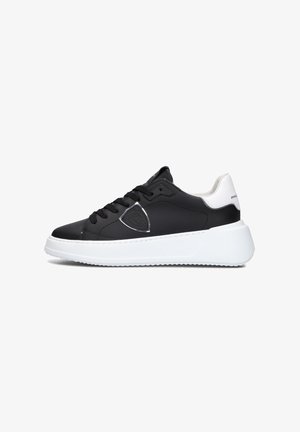 Zwarte leren sneakers met een witte rubberen zool, voorzien van een zilveren accent en zwarte veters. Rond neusdesign en gevoerde kraag.