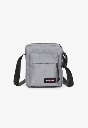 Szara torba messengera wykonana z trwałego materiału, z główną kieszenią na zamek, przednią kieszenią oraz regulowanym czarnym paskiem.