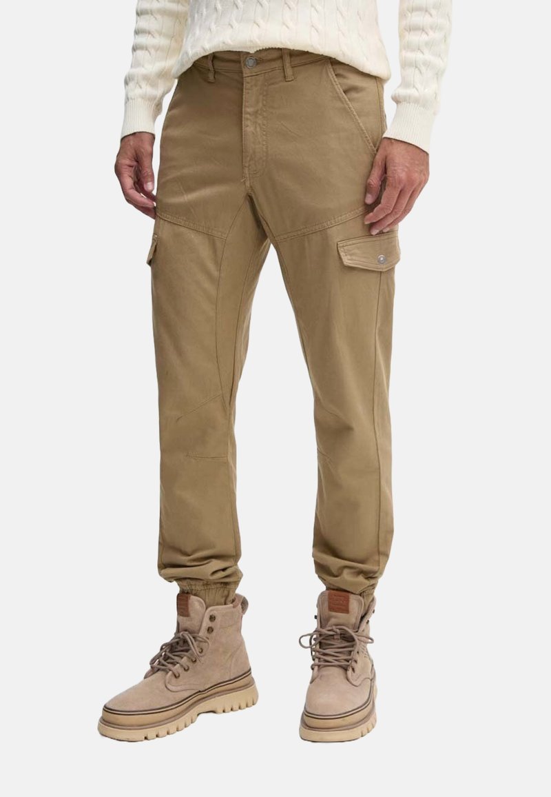 Pantalones cargo color caqui con puños elásticos, dos bolsillos laterales y un cierre frontal. Fabricados con un material duradero y de textura suave.