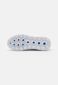 Suola di scarpa in gomma bianca che presenta motivi circolari con accenti blu, superficie texturizzata e perforazioni dello stesso spazio per una migliore aderenza.