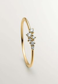 Anillo de oro con una banda delgada y suave que presenta cinco brillantes diamantes blancos dispuestos en un racimo. Los diamantes están engastados en garras elevadas.