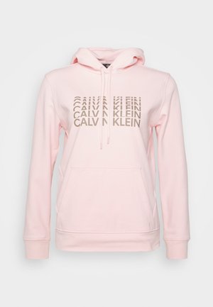 Sweat à capuche rose clair avec une poche kangourou à l'avant et le texte beige "Calvin Klein" répété quatre fois en design superposé sur la poitrine.