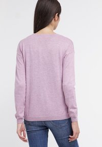 Light pink sweater with long sleeves, ribbed cuffs and hem, made of soft material, featuring a round neckline and a relaxed fit.
