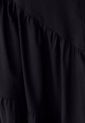 Schwarzes Kleid mit geschichteten Rüschen, strukturiertem Stoff und einem diagonalen Nahtdesign. Glatte Oberfläche mit kontrastierendem, gerafftem Detail am Saum.