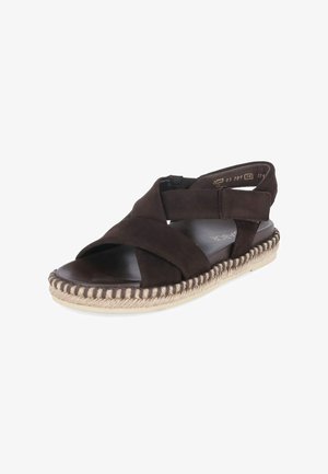Brown suede sandal with crisscross straps, velcro ankle closure, woven jute sole, and cushioned black footbed.