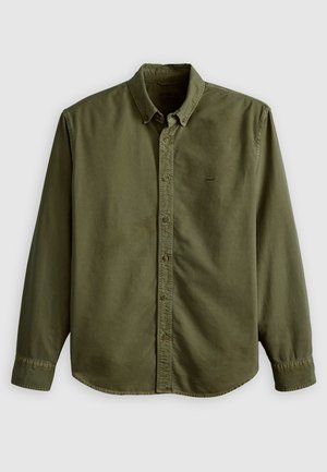 Olive green button-up shirt with a collar, long sleeves, and a rounded hem. Features a single chest pocket with subtle logo detail.