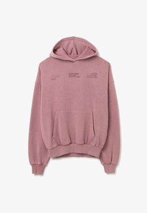 Oversized roze hoodie van zacht materiaal, met een voorzak en geribbelde zoom. Tekstgraphics op de borst met verschillende stadsnamen.