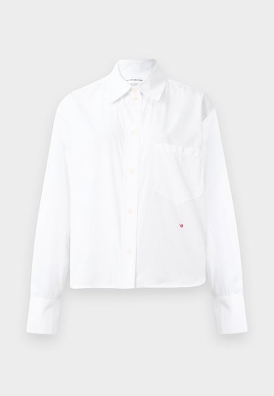 Kričavo biely dlhý rukáv košeľa s gombíkmi a špicatým golierom, s náprsním vreckom a malým červeným vyšívaným detailom "VB" blízko lemu.