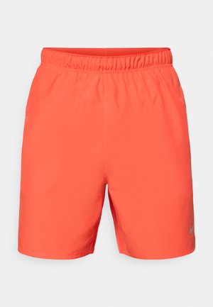 Nike svømmetights i lys orange, med elastisk talje, glat tekstur og en lille grå logoaccent på den nederste side.