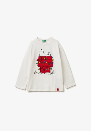 Bílé tričko s dlouhým rukávem, na kterém je obrázek Snoopyho na červeném psím domku ozdobeném barevnými vánočními světýlky. Červená visačka na lemu.